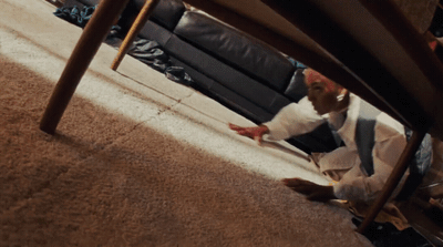 a man sitting on the floor under a chair