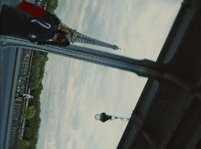 two people standing on a bridge looking at something in the distance