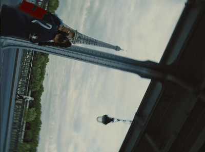 two people standing on a bridge looking at something in the distance