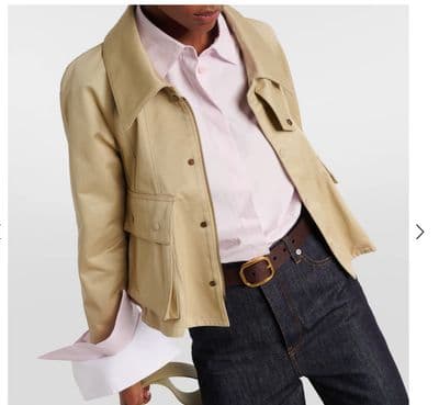 a woman in a white shirt and a tan jacket