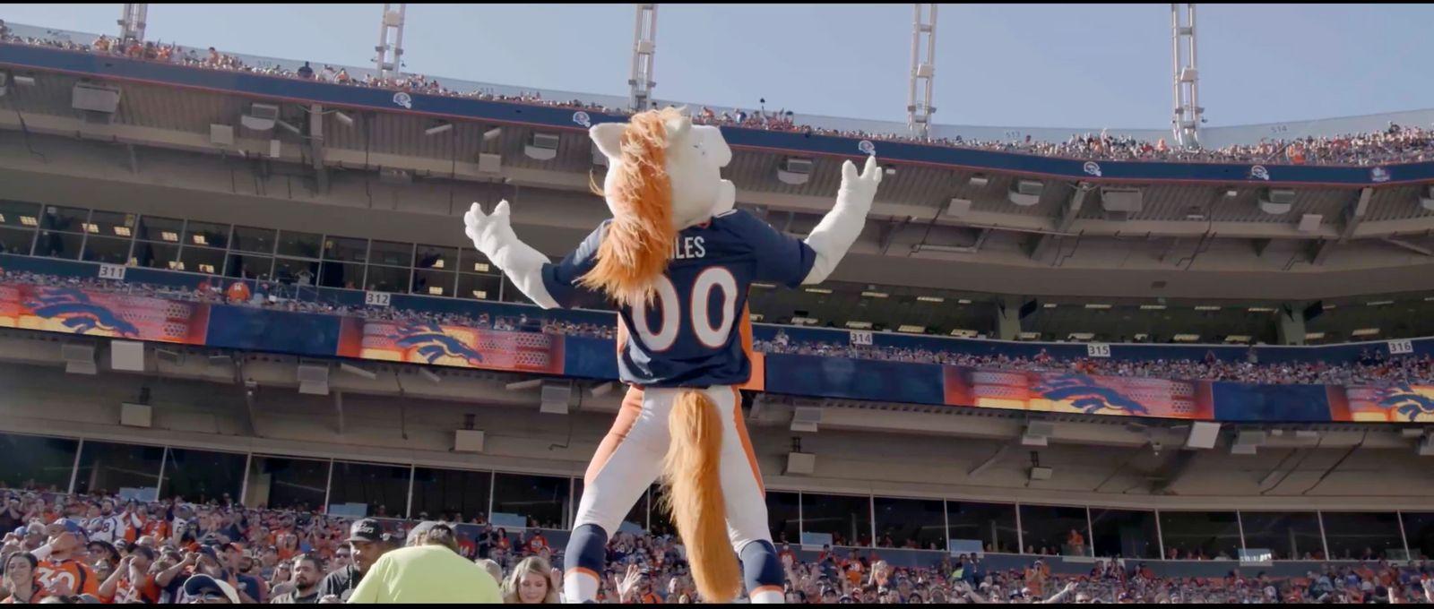 a person in a football uniform standing in front of a crowd