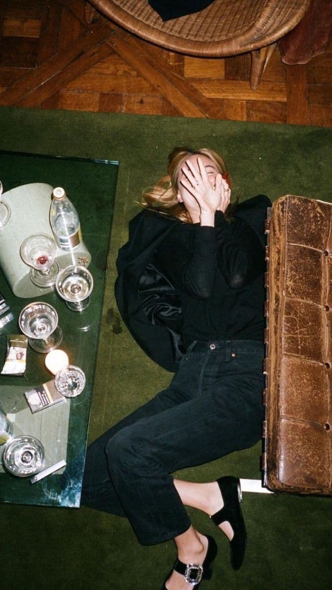 a woman laying on the floor next to a suitcase