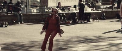 a woman in a red suit walking down a street