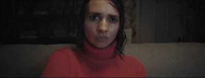 a woman in a red sweater sitting on a couch