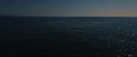 a large body of water under a blue sky