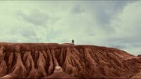 a person standing on top of a large hill