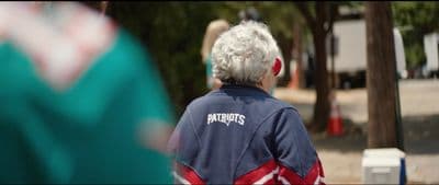 a woman with white hair walking down a street