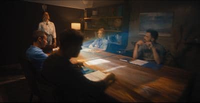a group of people sitting around a wooden table