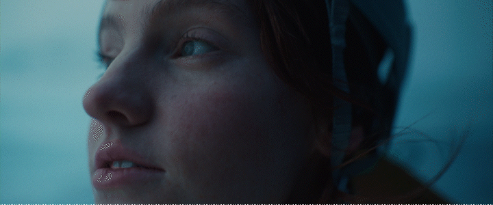 a close up of a woman's face with the sky in the background