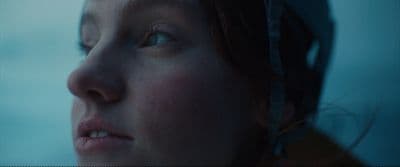 a close up of a woman's face with the sky in the background