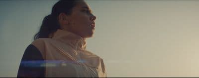 a woman in a pink jacket looking off into the distance