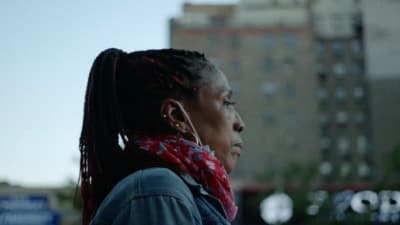 a woman with dreadlocks standing in the street