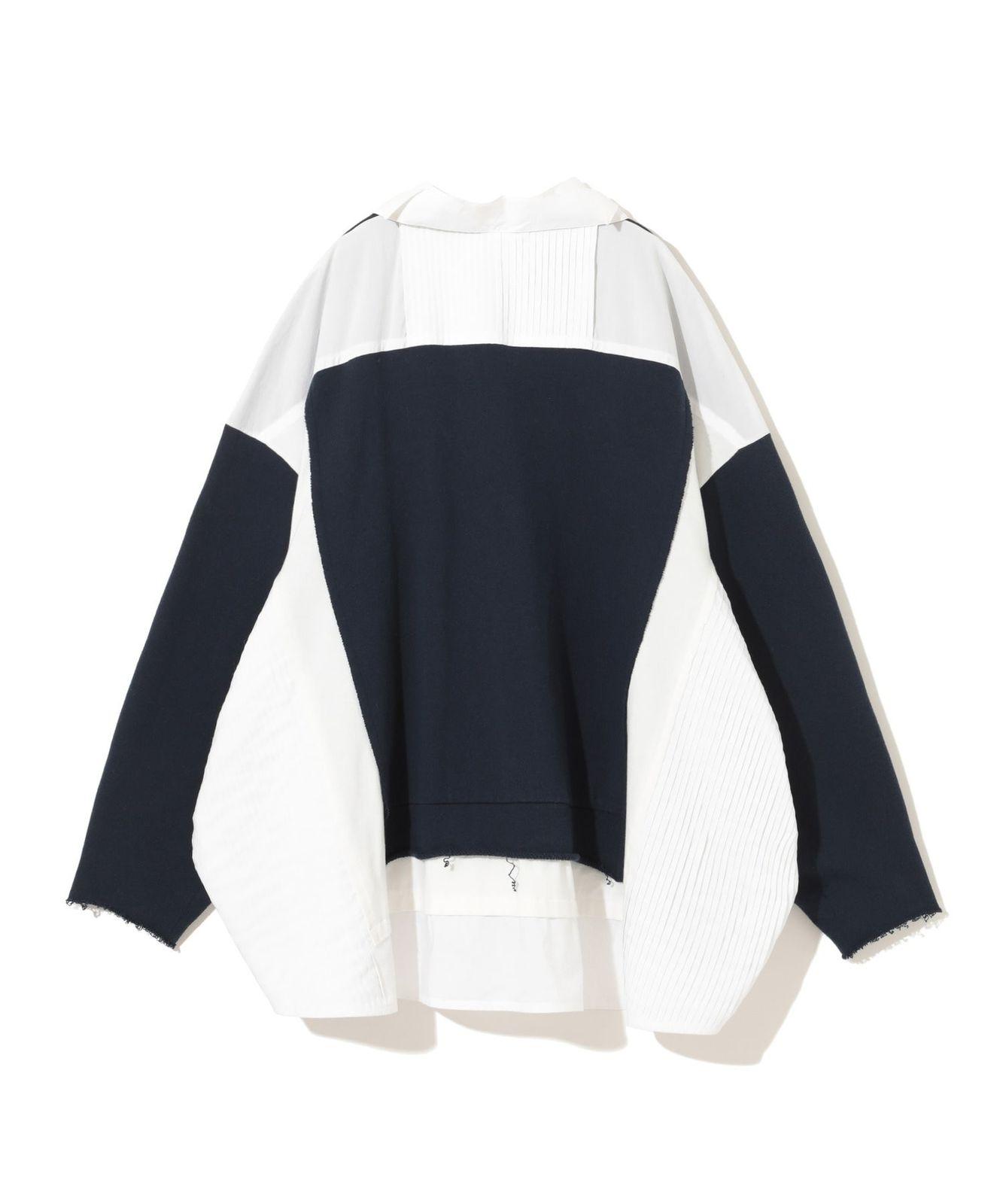 a black and white sweater hanging on a hanger