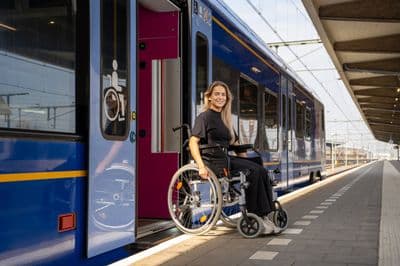 a woman in a wheelchair next to a train