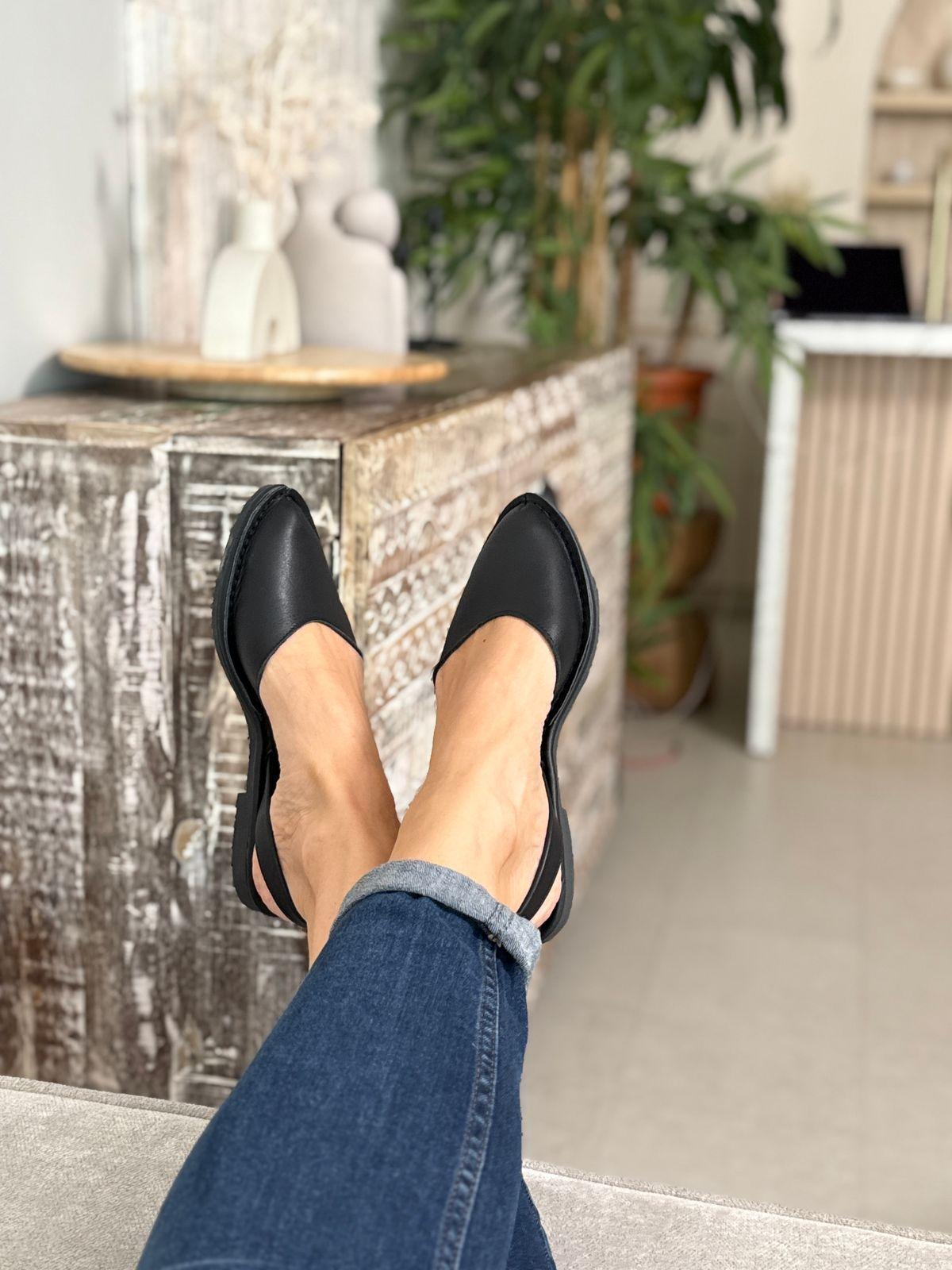 a woman's legs with black shoes and jeans