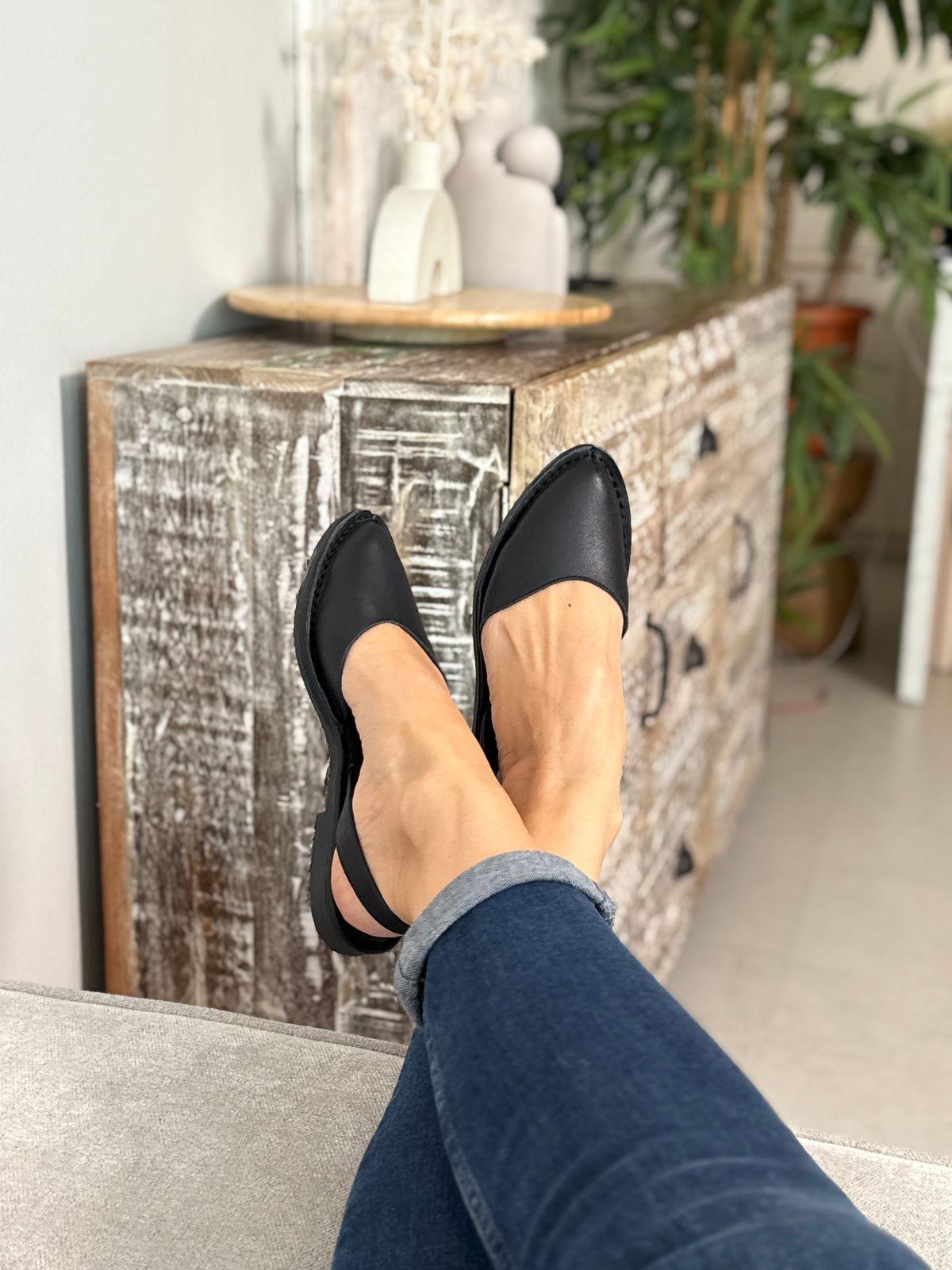 a woman's feet wearing black shoes and jeans