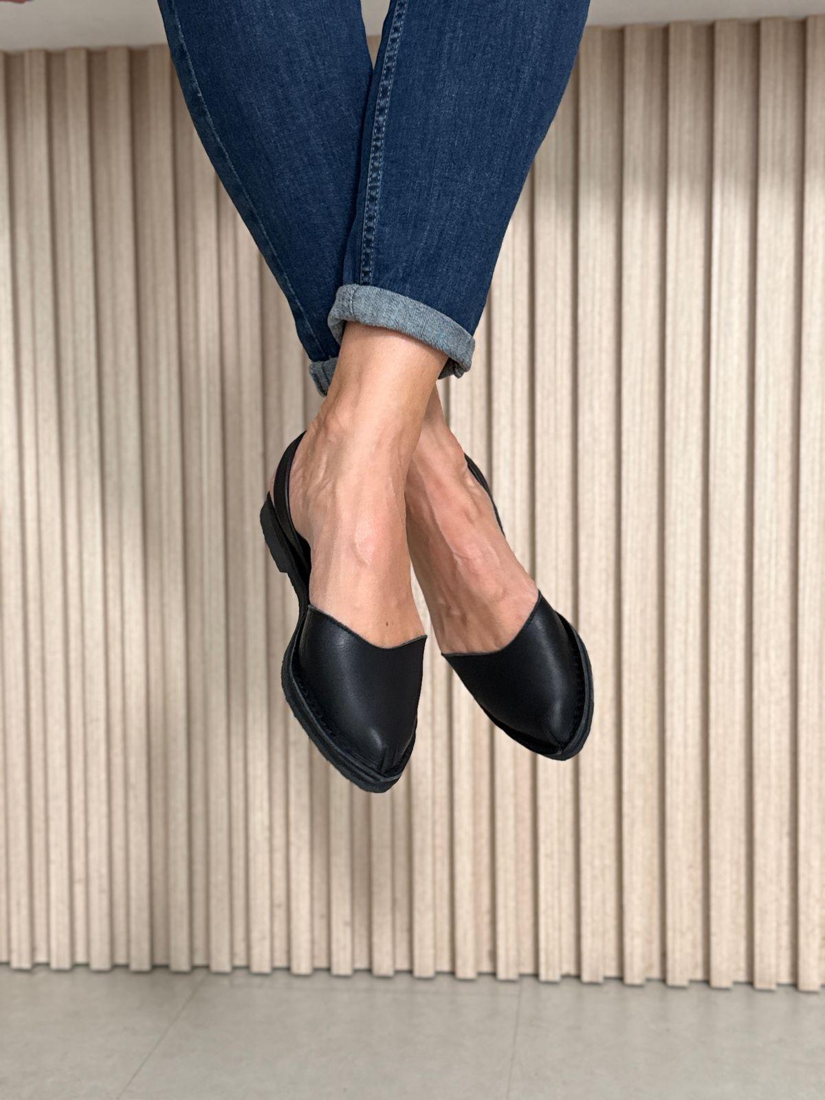 a woman's feet in a pair of black shoes