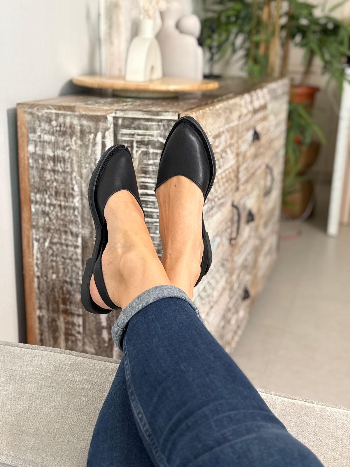 a woman's feet wearing black shoes and jeans