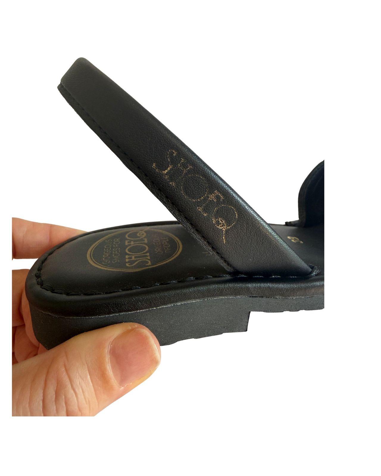 a person is holding a black flip flop