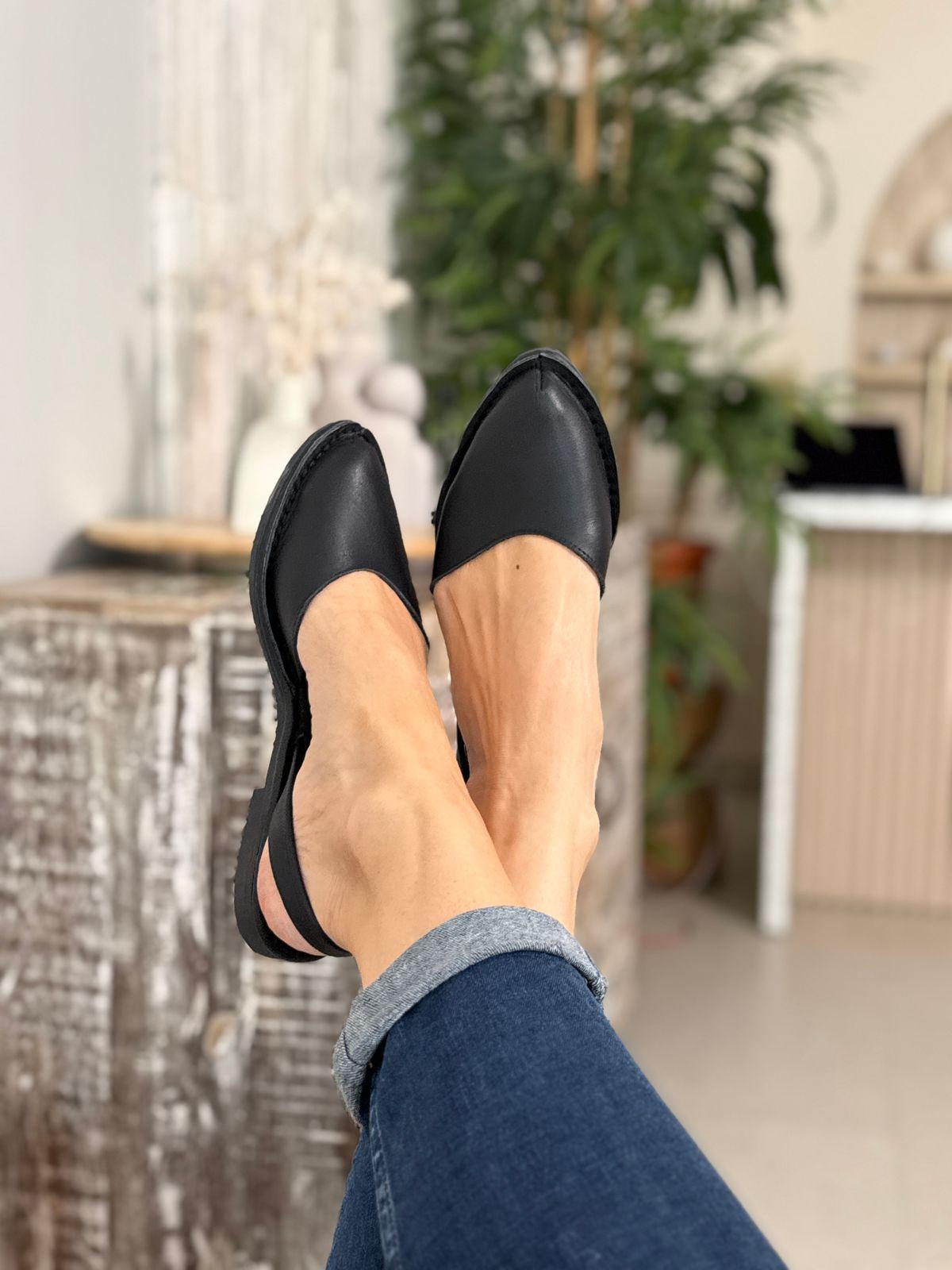 a woman's feet wearing black shoes and jeans