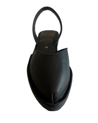 a black leather shoe with a circular heel