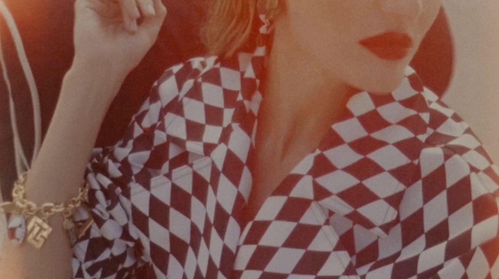 a woman in a checkered shirt smoking a cigarette
