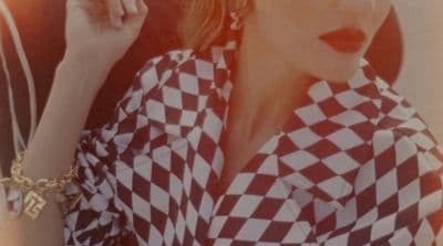 a woman in a checkered shirt smoking a cigarette