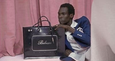 a man sitting on a couch holding a black bag