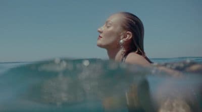 a woman swimming in the ocean with her head above the water