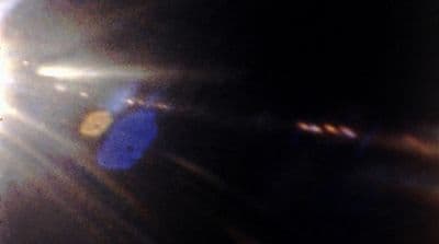 a blurry photo of the sun shining through the lens