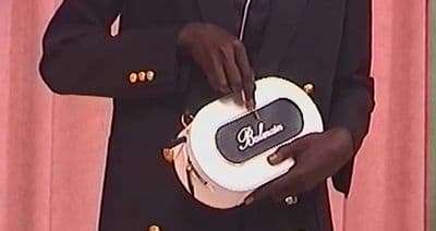 a man in a suit holding a white and black object