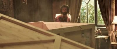 a man standing in a room next to a window