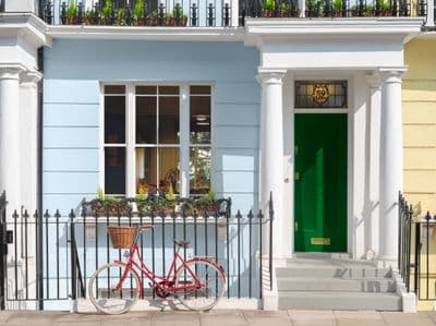 a red bicycle parked in front of a blue building