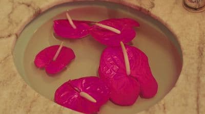 a plate of pink candles on a marble table