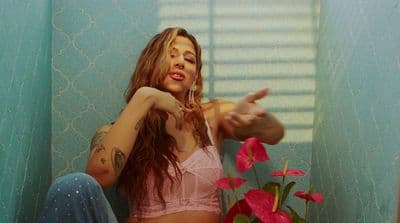 a woman in a pink bra top sitting on a toilet