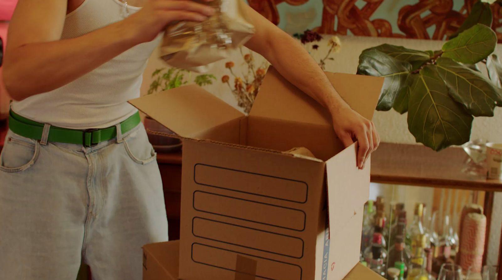 a man holding a wine glass in a cardboard box