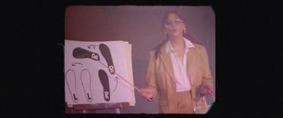 a man standing in front of a painting holding a paintbrush
