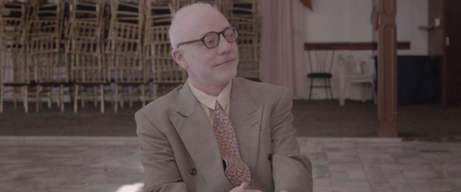 a man in a suit and tie sitting down