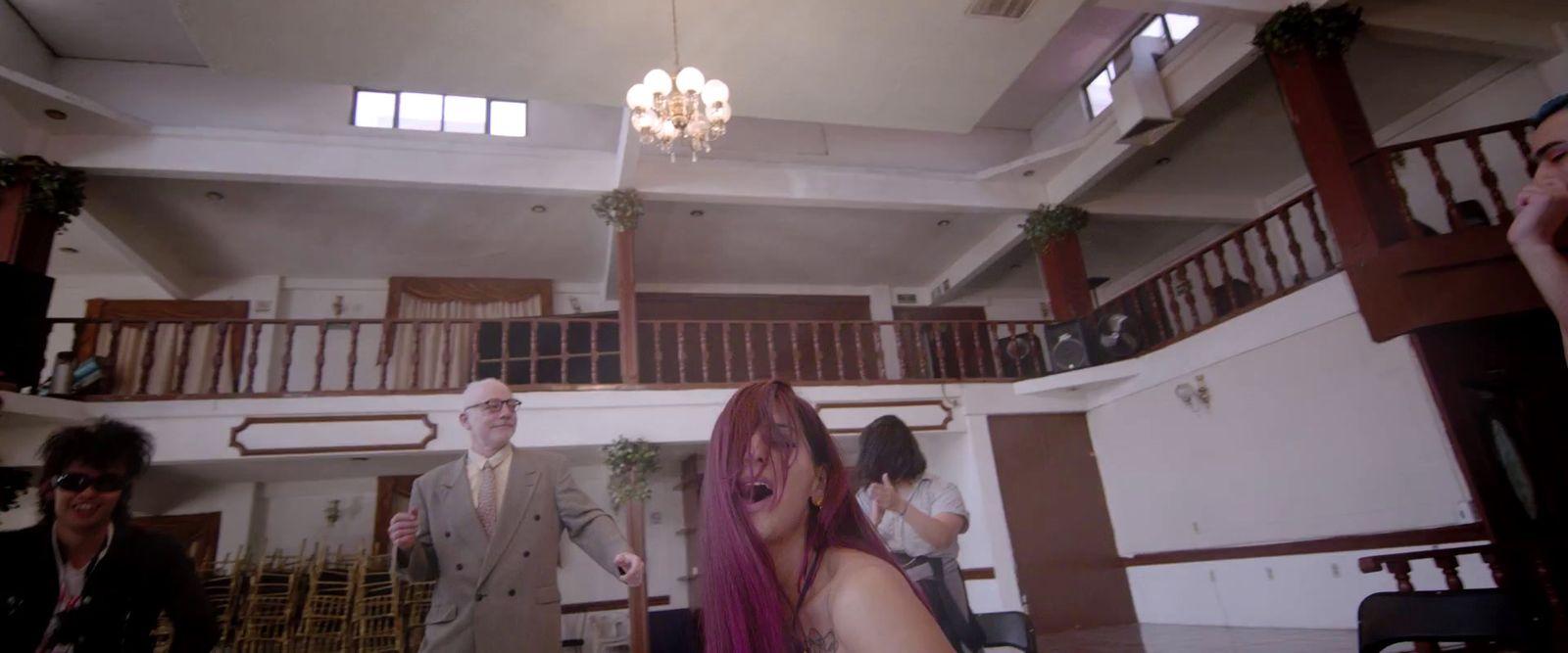 a group of people in a room with a chandelier