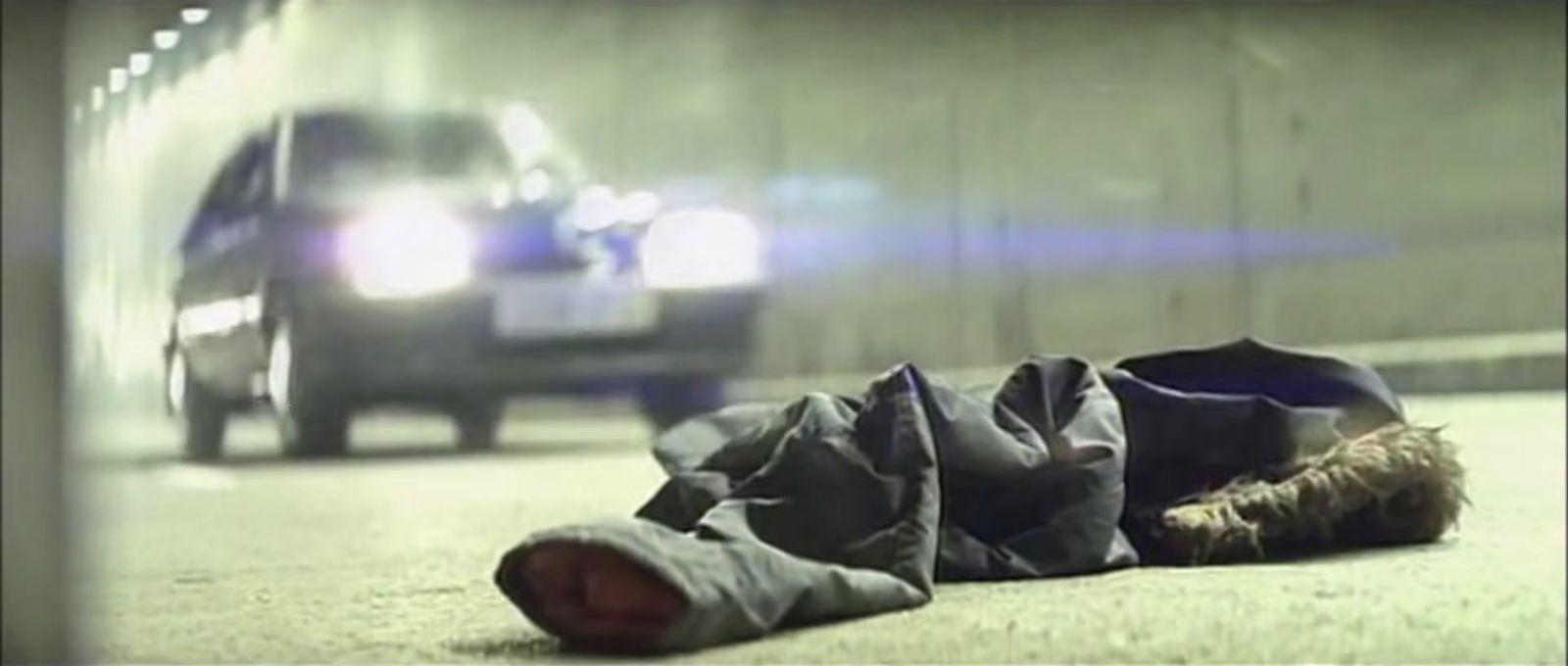 a pair of shoes laying on the ground next to a car