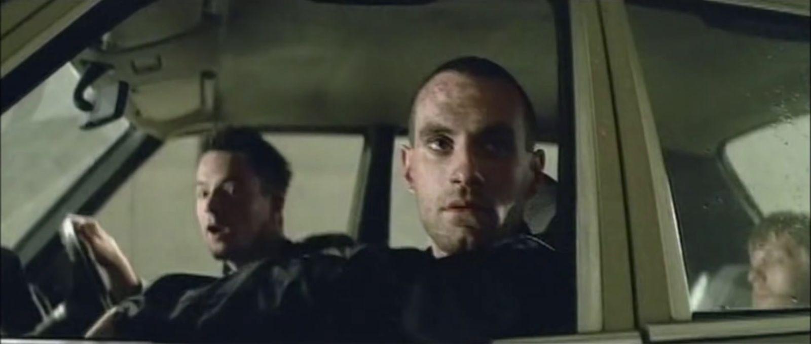a man driving a car with another man in the passenger seat