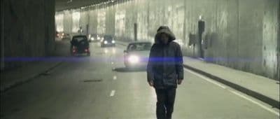 a man walking down a street in a tunnel
