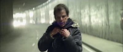 a man standing in a tunnel holding a cell phone