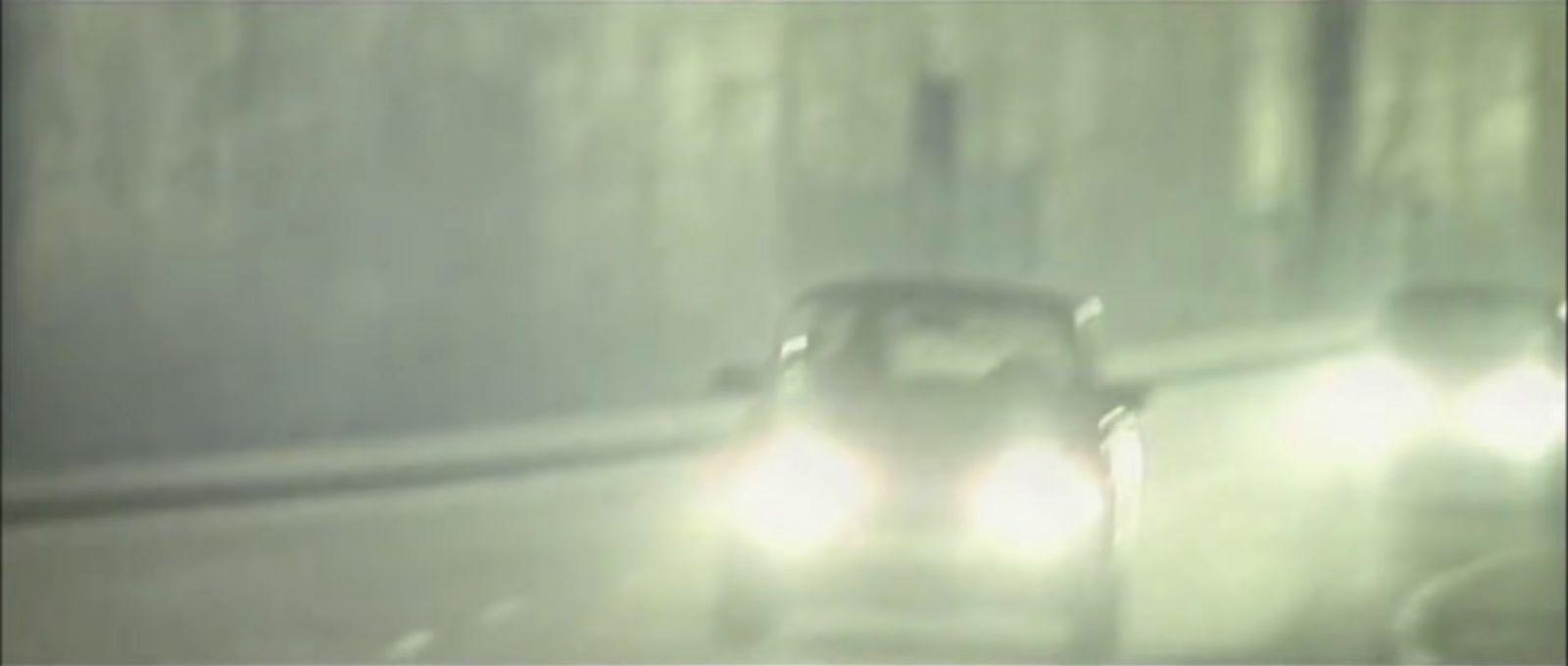 a car driving down a street in the rain