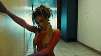 a woman in a red and gold outfit is dancing