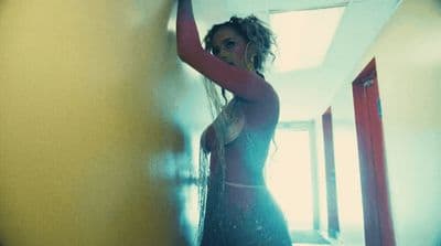 a woman in a black dress standing in a hallway