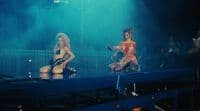 a couple of women standing on top of a stage