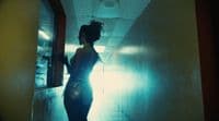 a woman standing in a hallway in a dark room