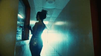 a woman standing in a hallway in a dark room