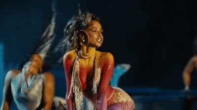 a woman in a red and gold dress is dancing